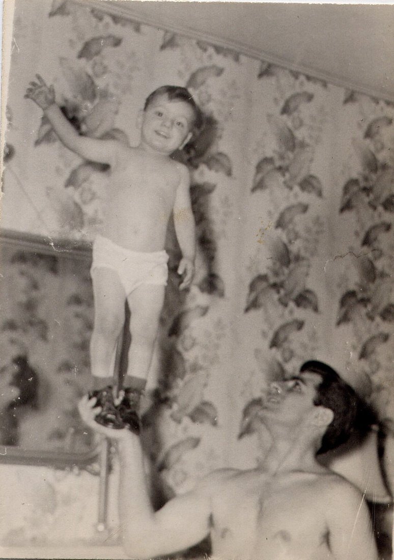 A father lifts his son up to the wallpaper